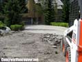 Bobcat removing badly broken asphalt driveway in Whistler, BC, Canada